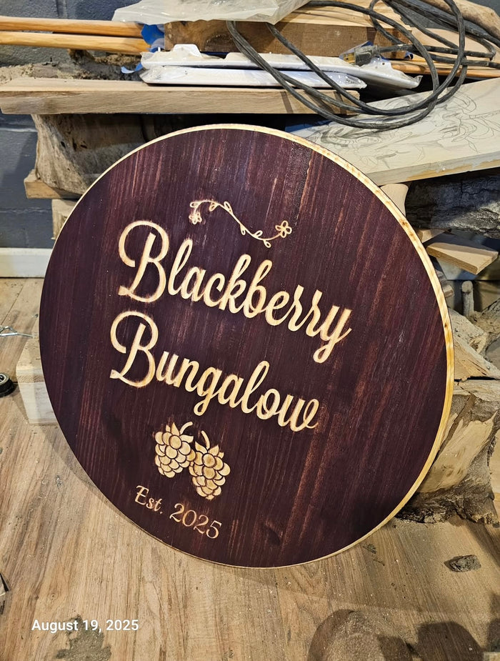 Blackberry Bungalow — a round custom sign with carved script and fruit detail.