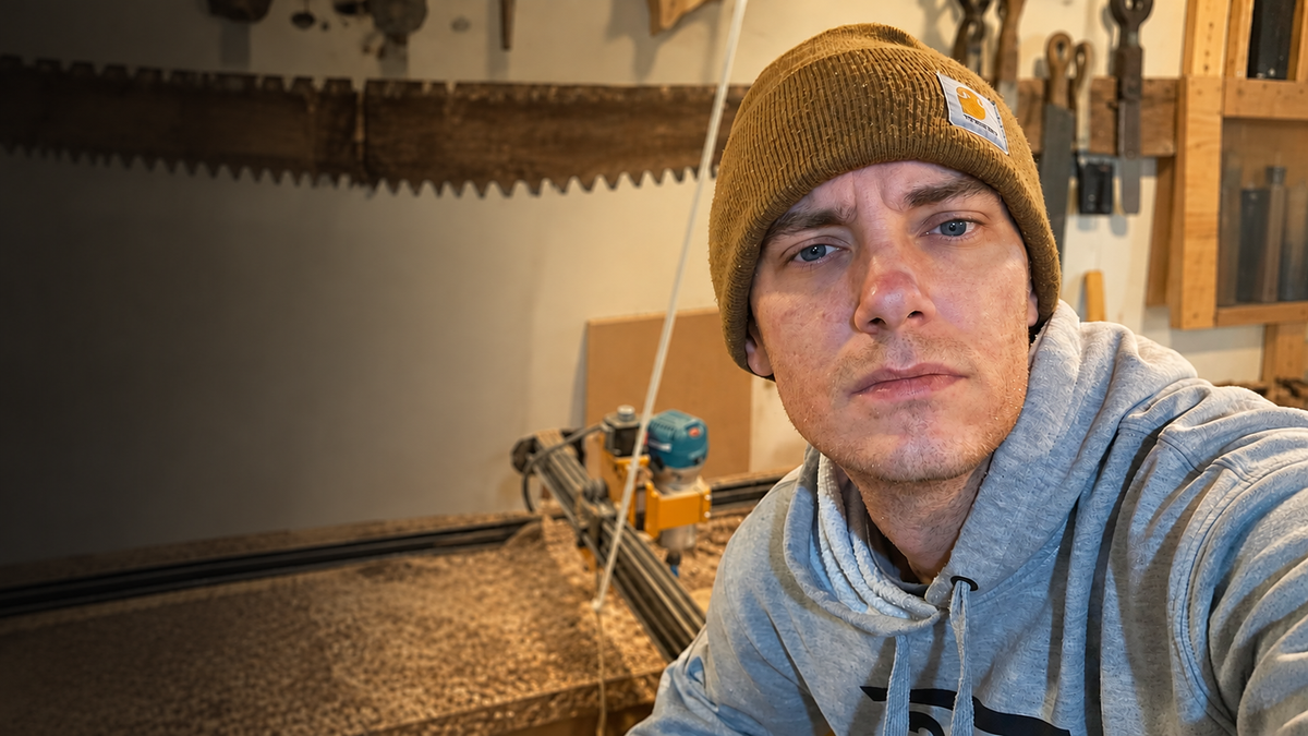 Joshua Vargovich beside his CNC machine in his woodworking shop